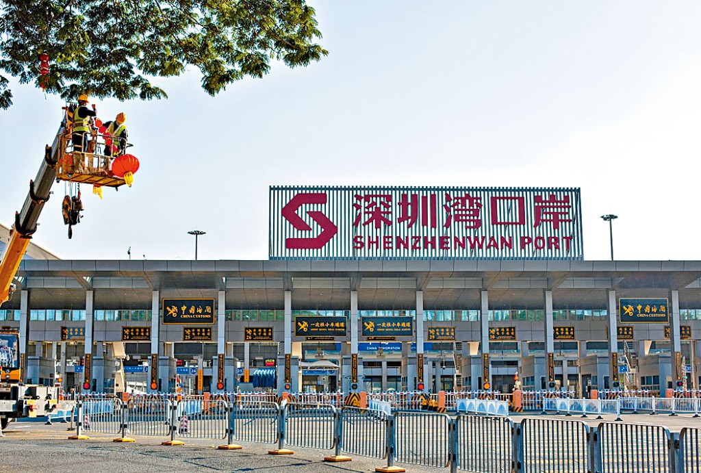 深圳灣口岸為通關做好準備，有工作人員在樹上掛起紅燈籠。