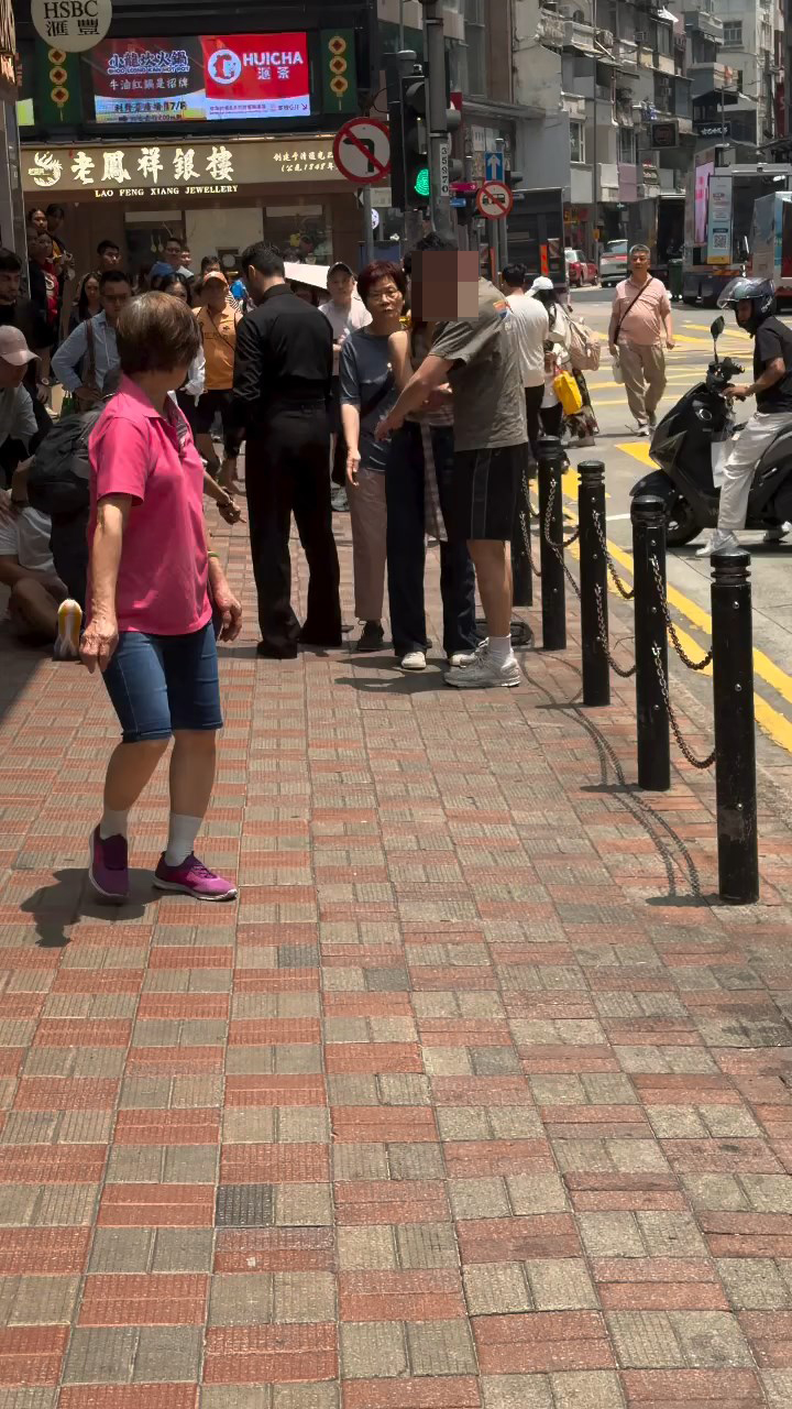 綠色衫的男子頭部受傷流血，與同行女子站在銅鑼灣廣場二期對開的欄杆旁邊。Threads@wkmik片段截圖