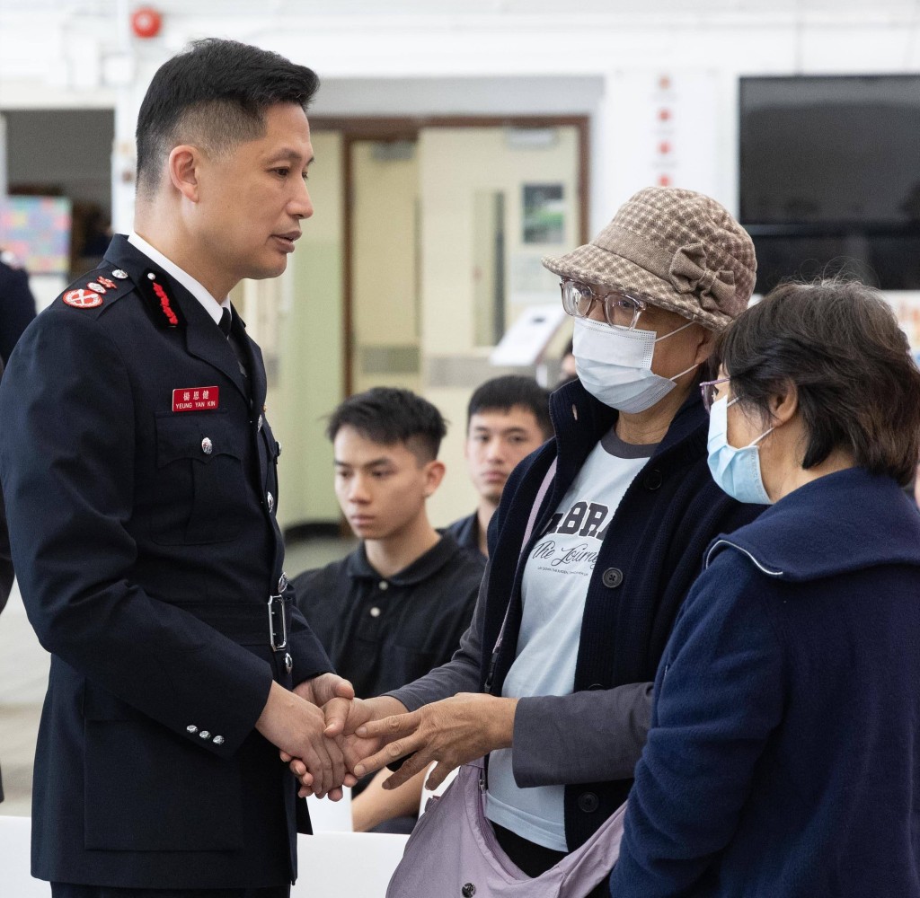 宏福苑火災中兩位獲救者亦有參與何偉豪的追授儀式，消防處處長楊恩健（左一）與他們交談。