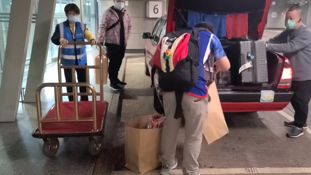 職員會等待旅客將行李搬上的士後收回。