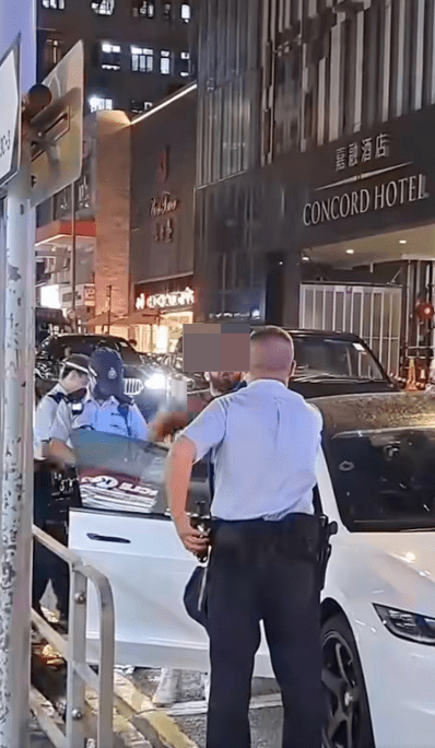 外籍男情緒失控,在其白色Tesla私家車旁邊不斷用不純正的廣東話向警員爆粗辱罵。fb@突發馬路車cam大全(下同) 外籍男情緒失控,在其白色Tesla私家車旁邊不斷用不純正的廣東話向警員爆粗辱罵。fb@突發馬路車cam大全(下同)