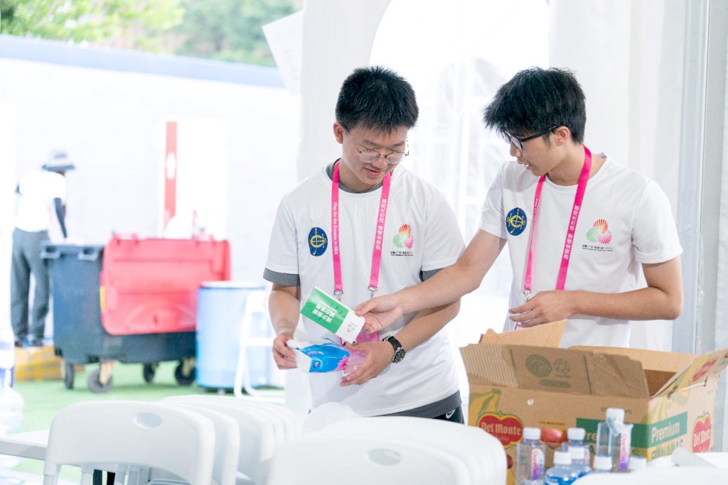 青年義工王煜崴跟隊友為鐵人三項比賽的 運動員整理補給物資。