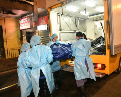仵工將遺體抬上車運走。丁志雄攝