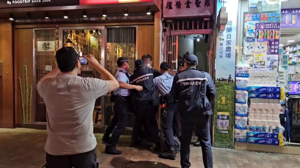 片段開始時黑衫男已被5名警員按在牆邊。香港突發事故報料區FB
