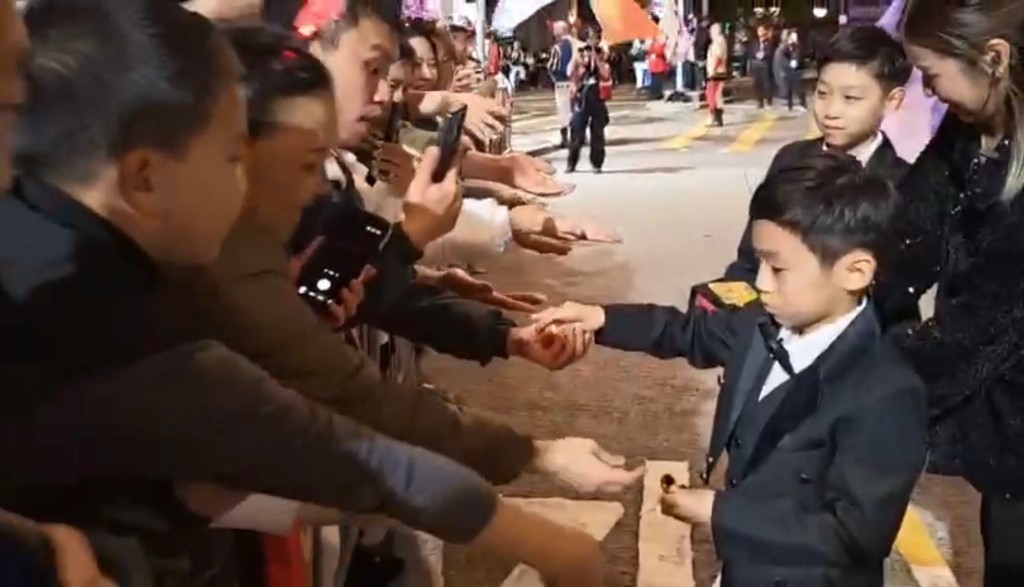 小齐两位仔仔亦有同行，向两旁的游客及市民表演金币魔术。