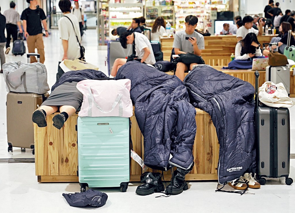 受到豪雨影響，大批旅客滯留日本成田機場，部分人靠睡袋過夜。