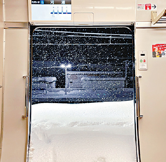 ■河瀨站的電車車門打開後，可見積雪足足有半個車廂高。網圖