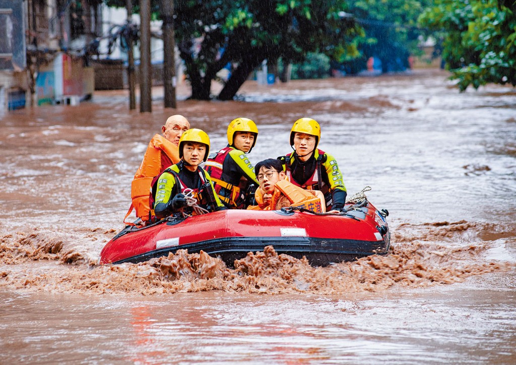 重庆万州消防人员携带冲锋舟营救被困民众。
