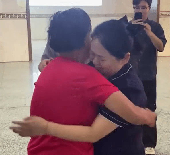 秦娜在西安火车站与失踪了23年的母亲拥抱。