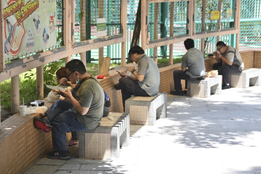 禁堂食令下，市民要在烈日之下食飯盒。