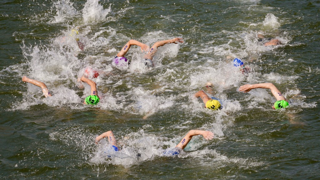 男子三項鐵人賽參加者在塞納河中游泳。 美聯社