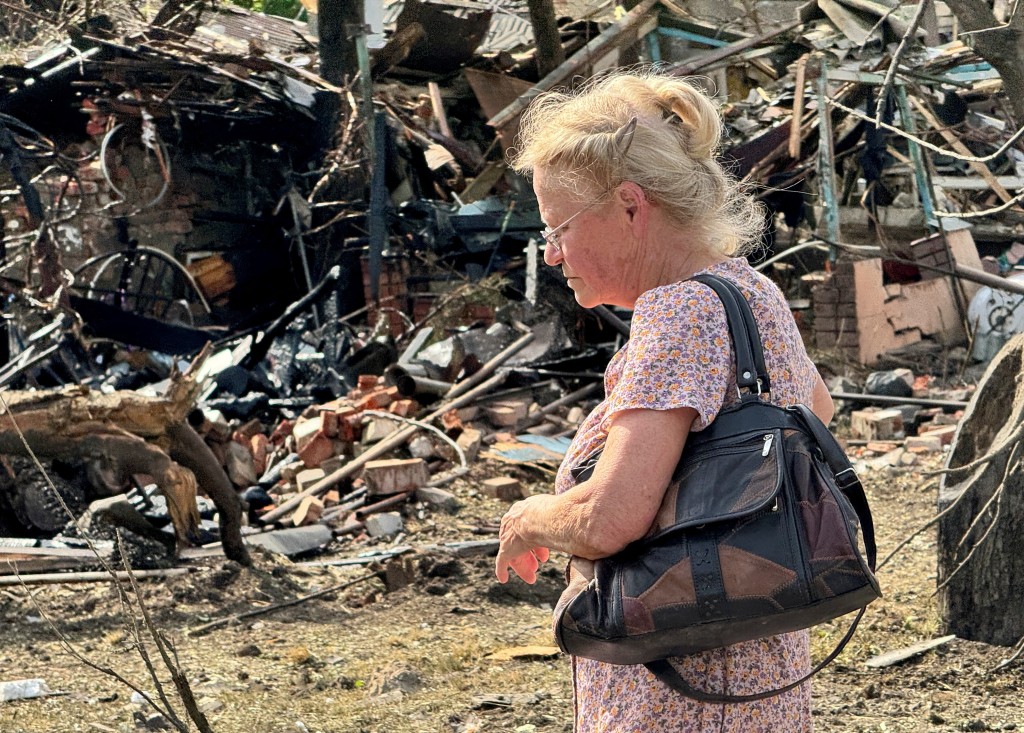 一名乌克兰妇人在被毁民宅前。（路透社）