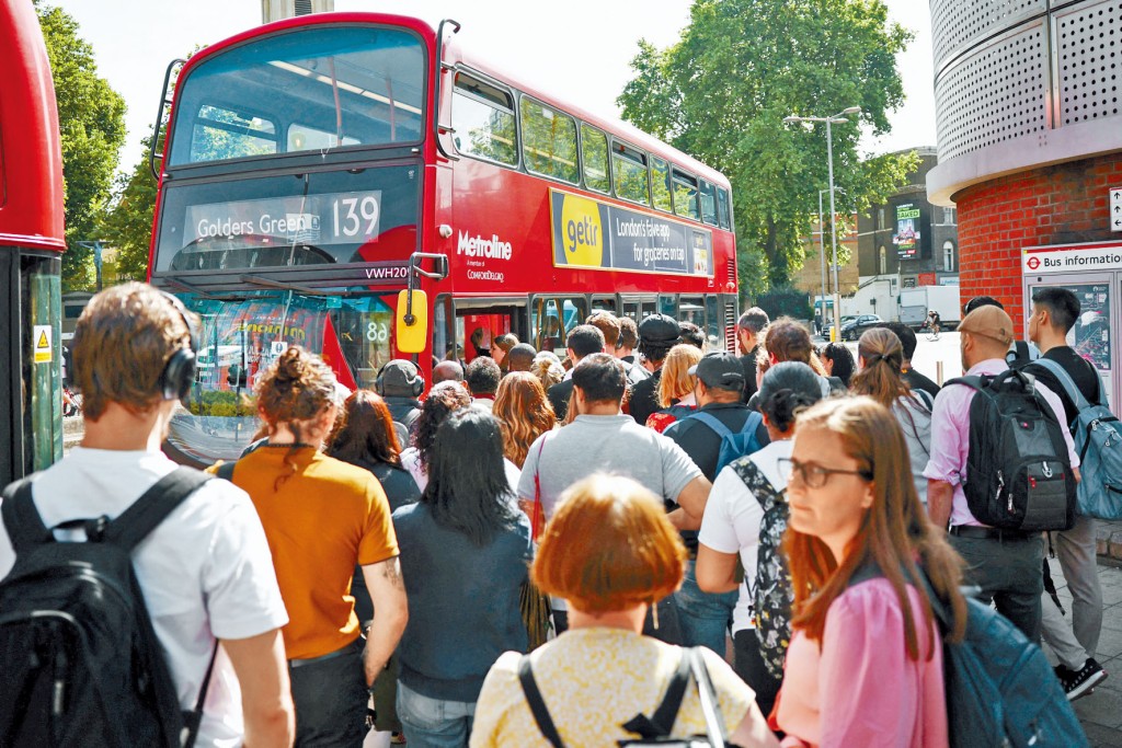 英國鐵路大罷工首日,倫敦滑鐵盧站外出現排隊等候巴士的人潮。