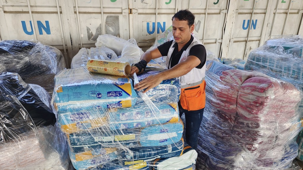聯合國和紅新月會工作人員在近東救濟工程處（UNRWA）倉庫準備向巴勒斯坦人分發援助物資。 美聯社