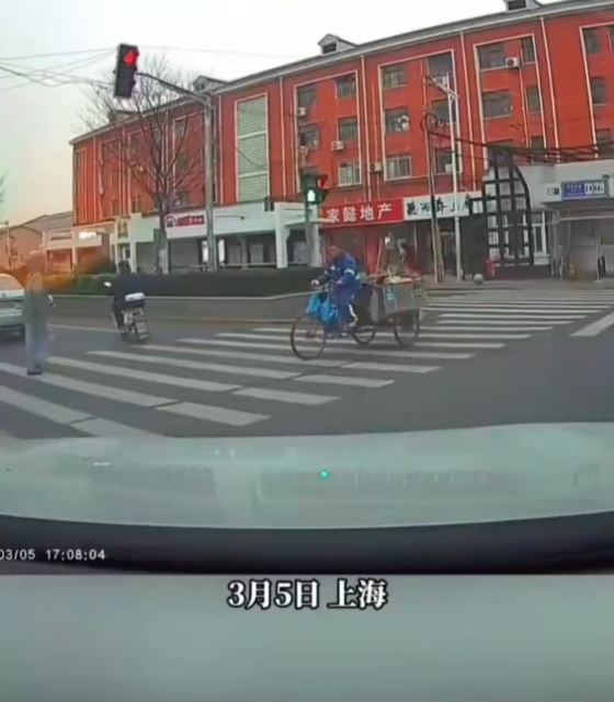 女司机转弯前停车，礼让使用斑马线的路人。