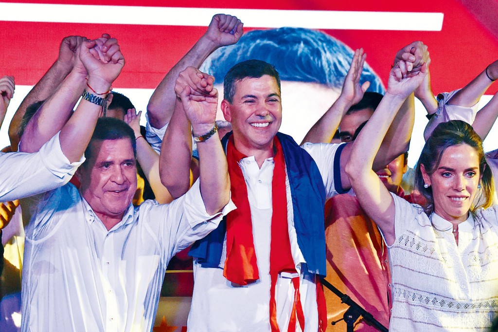 巴拉圭執政紅黨候選人培尼亞贏得大選後,與妻子(右)和前總統卡提斯歡呼慶祝。