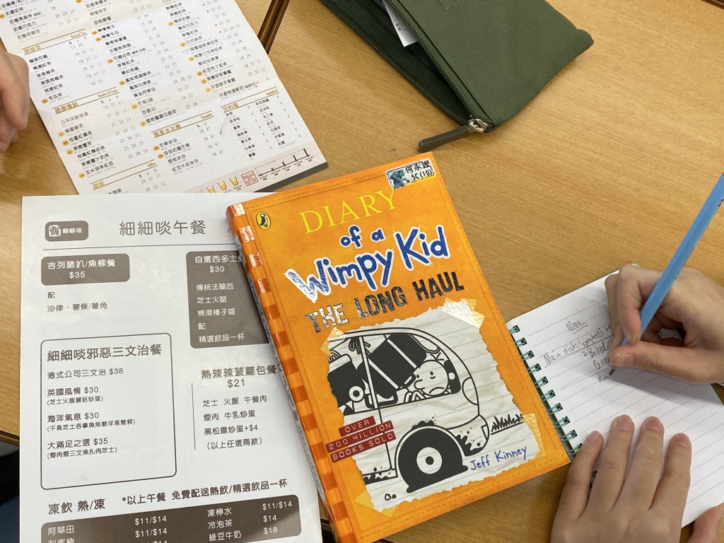 ■教學主題圖書之一是《Diary of a Wimpy Kid：The Long Haul》，三年級學生參考內容，配合茶餐廳點餐紙，分組與同學討論撰寫食譜。