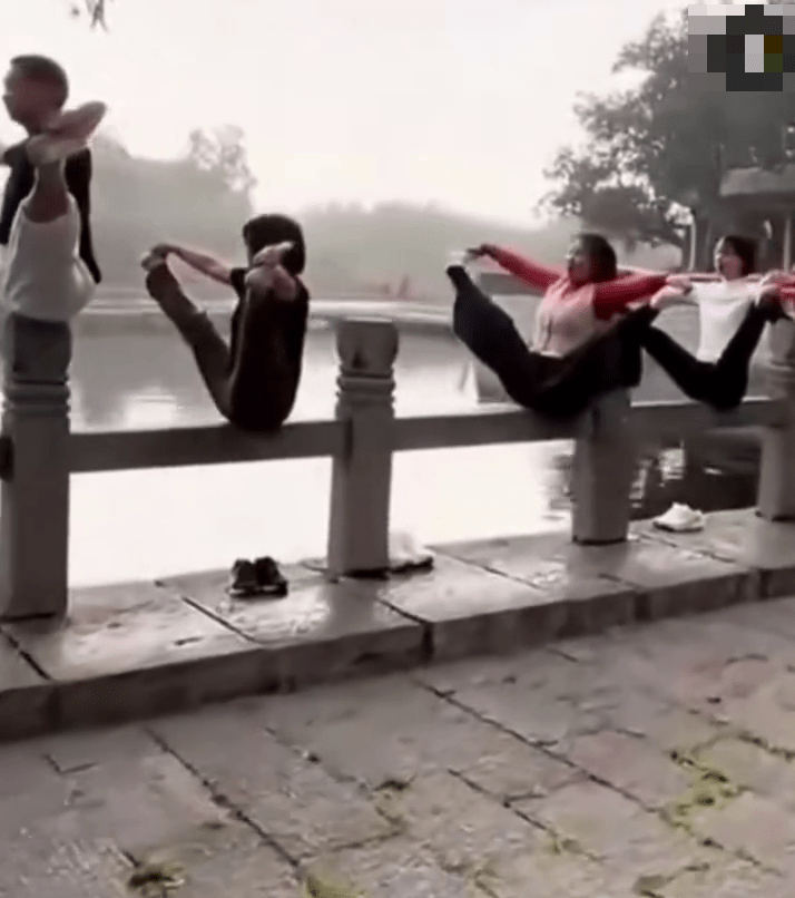 多名大媽將湖邊石欄杆的柱頭當成「瑜伽墊」，大玩高難度「擘髀」動作。