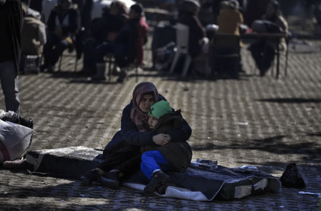 一名婦女和其他人坐在土耳其南部阿德亞曼的一個公共花園裡，擁抱著她的兒子。AP