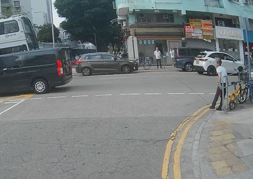 她走到對面馬路鐵欄旁。fb車cam L（香港群組）影片截圖