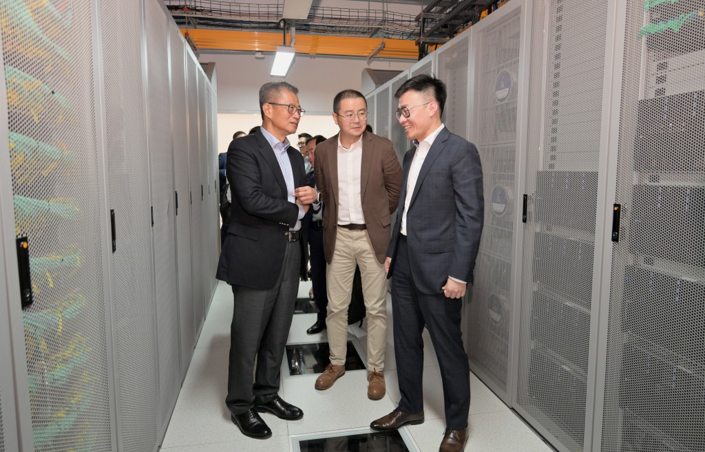 陳茂波（左）在商湯智能科技聯合創始人徐冰（右）陪同下，參觀其公司設施。政府新聞處