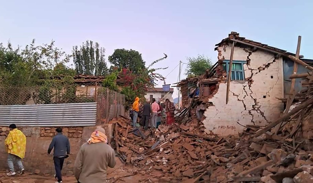 有人在倒塌的房屋中挖开瓦砾救出生还者。 AP