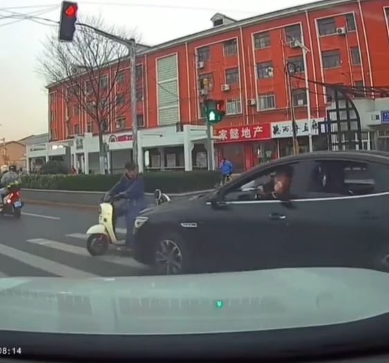 黑色车司机不满女事主停车让路人，举中指挑衅，却撞到一名骑电动车的大叔。