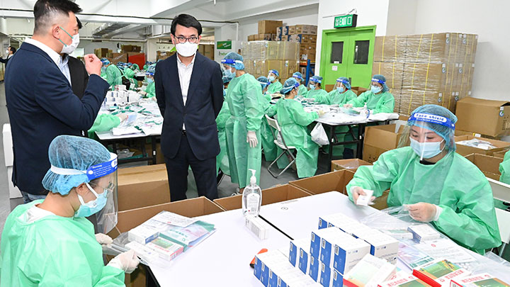 邱騰華視察政府委託的一家抗疫物資包包裝工埸。政府新聞處圖片