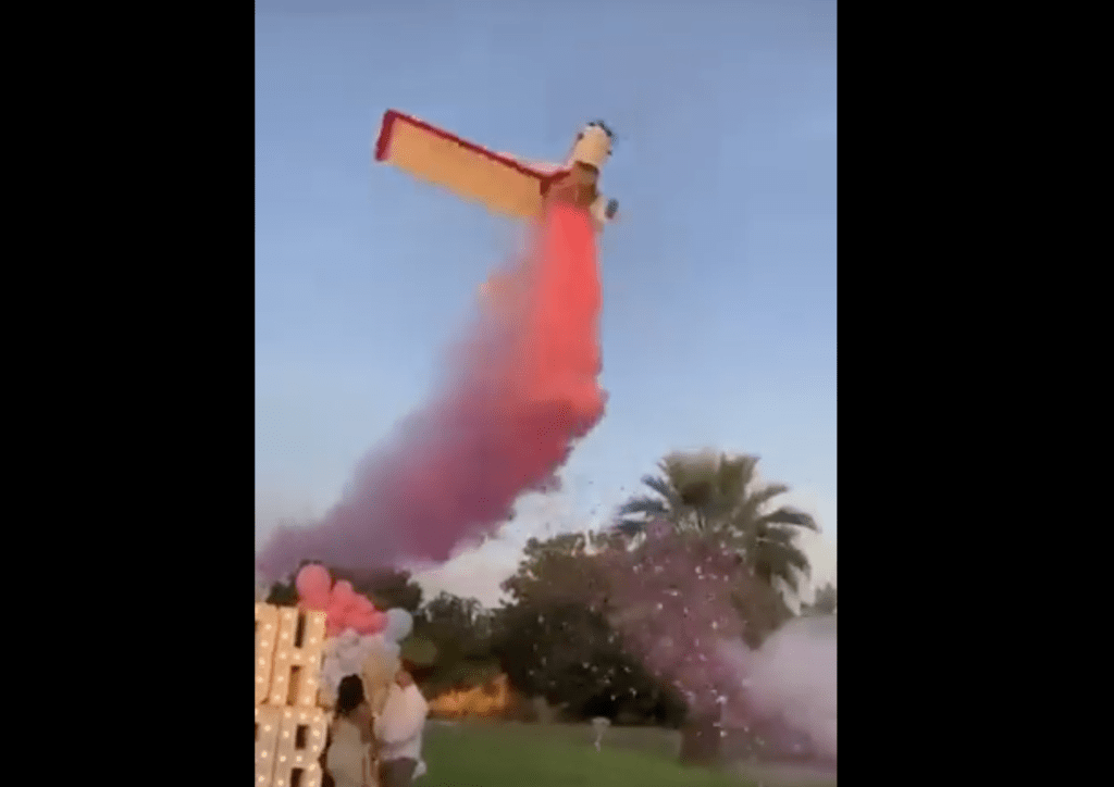 飞机机身向下洒出粉红色的烟雾，表明他们将有一个女儿。