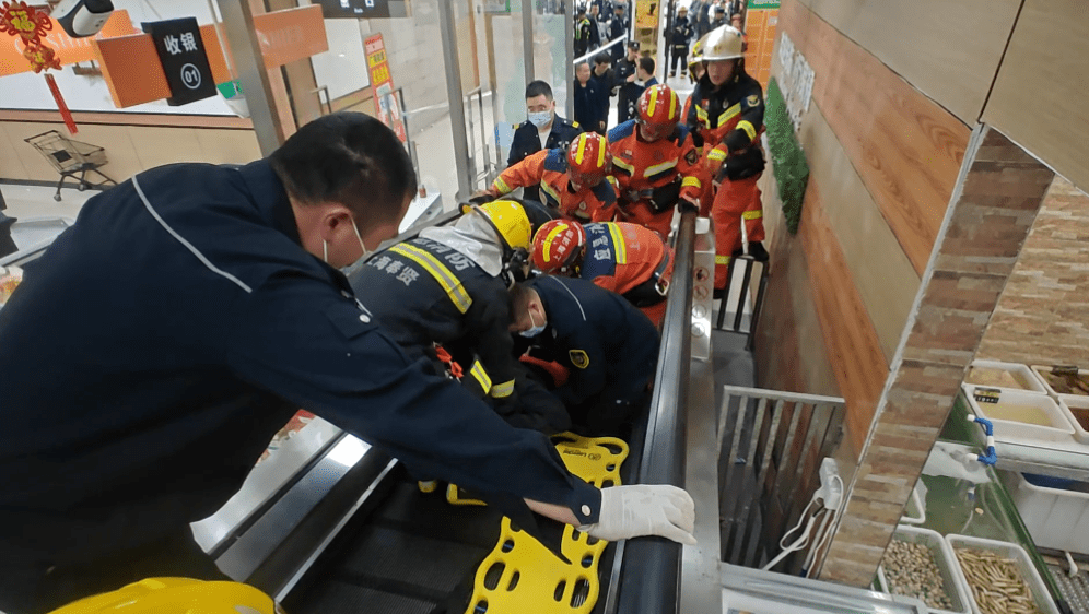 消防员在电梯工程人员帮助下救人。