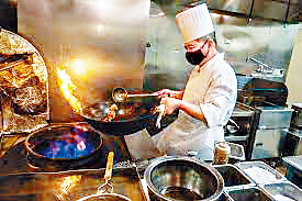 三藩市中餐館的廚師用燃氣爐烹飪。