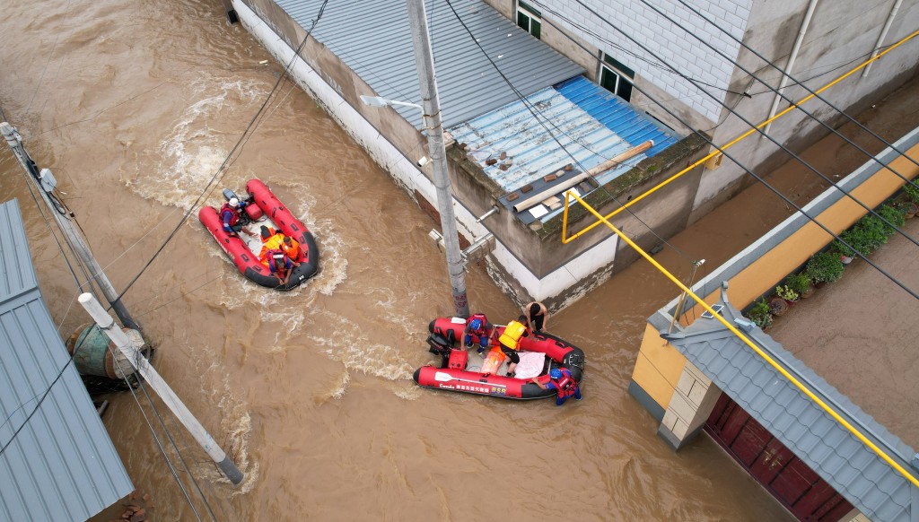 救援人员在河北涿州灾区搜救被困灾民。 中新社