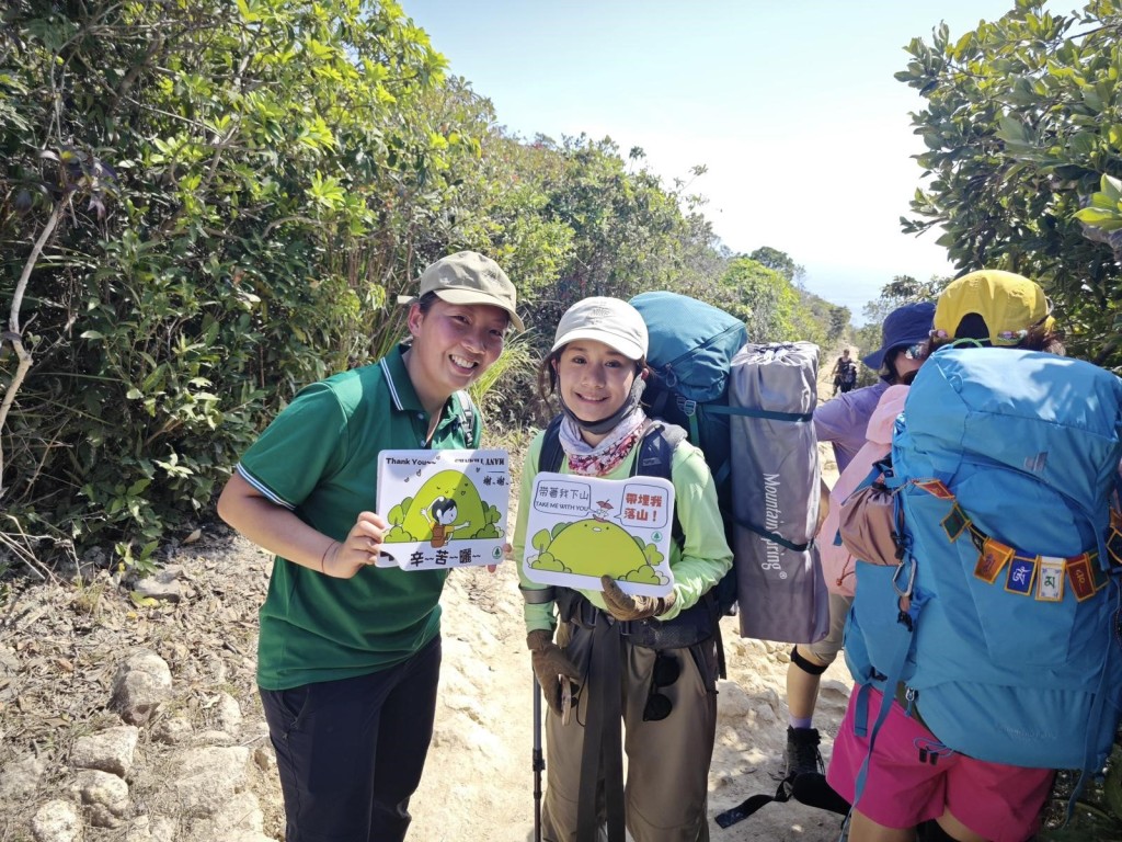 漁護署義工隊成員在西貢西灣山附近一帶向遊人宣傳「自己垃圾自己帶走」。政府新聞處
