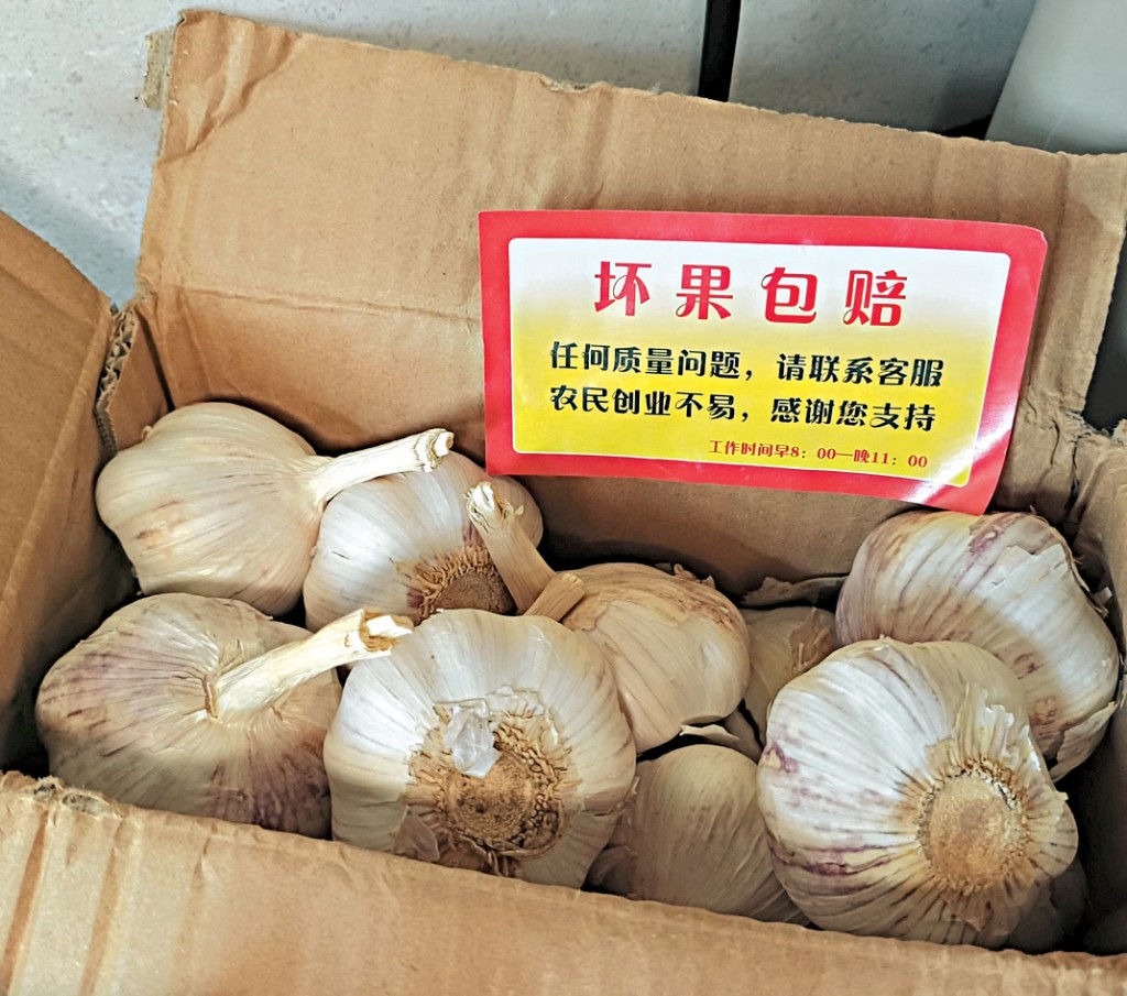 市民陈先生展示近日网购的山东大蒜，包装纸盒附有「坏果包赔」字条。