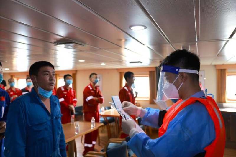 三亚边检站民警正在对船上人员进行人证对照。