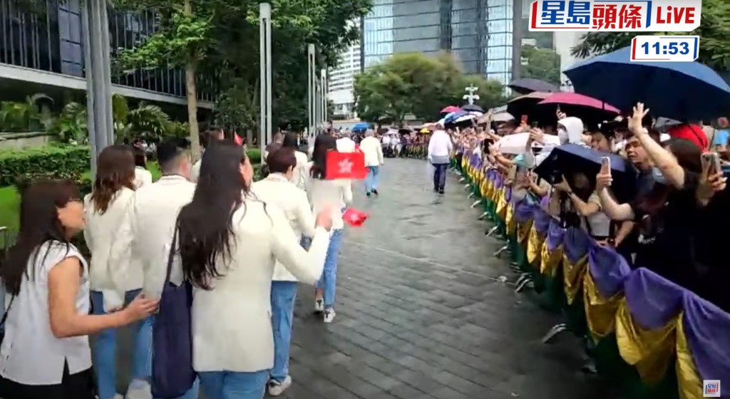 添馬公園路旁亦有眾多市民冒雨等待，一眾運動員與在場的市民揮手。