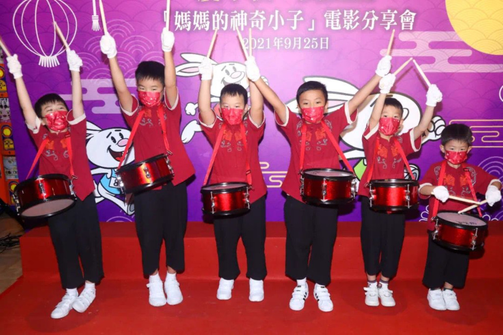 港岛妇联会员的儿子们组成了「香江小鼓队」，金铃的仔仔（左二）亦是其中一分子。