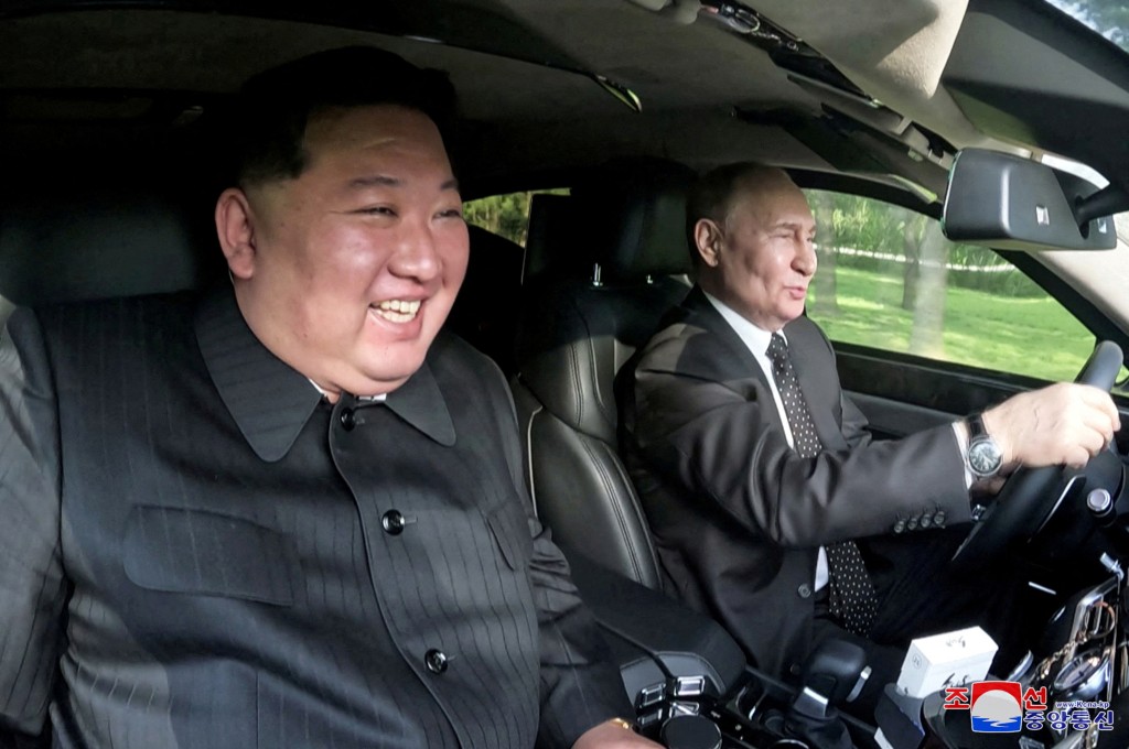 普京（右）上月曾訪問北韓首都，駕車載金正恩游車河。路透社