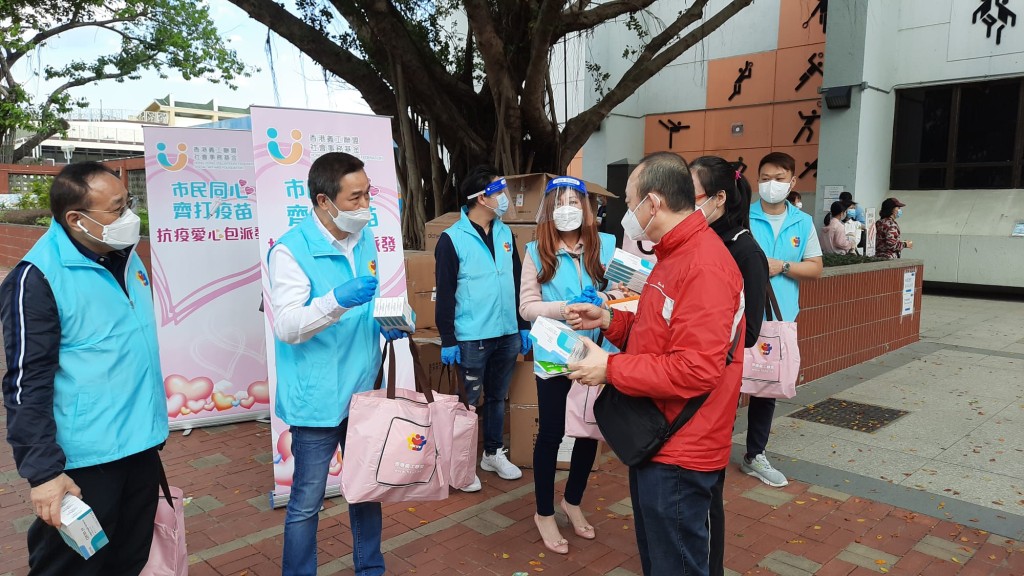 香港義工聯盟向每位接種疫苗的市民派贈內含5盒快測套裝的「抗疫愛心包」。