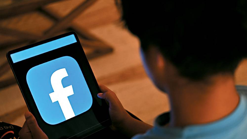 一個孩童在瀏覽社交網Facebook。 法新社