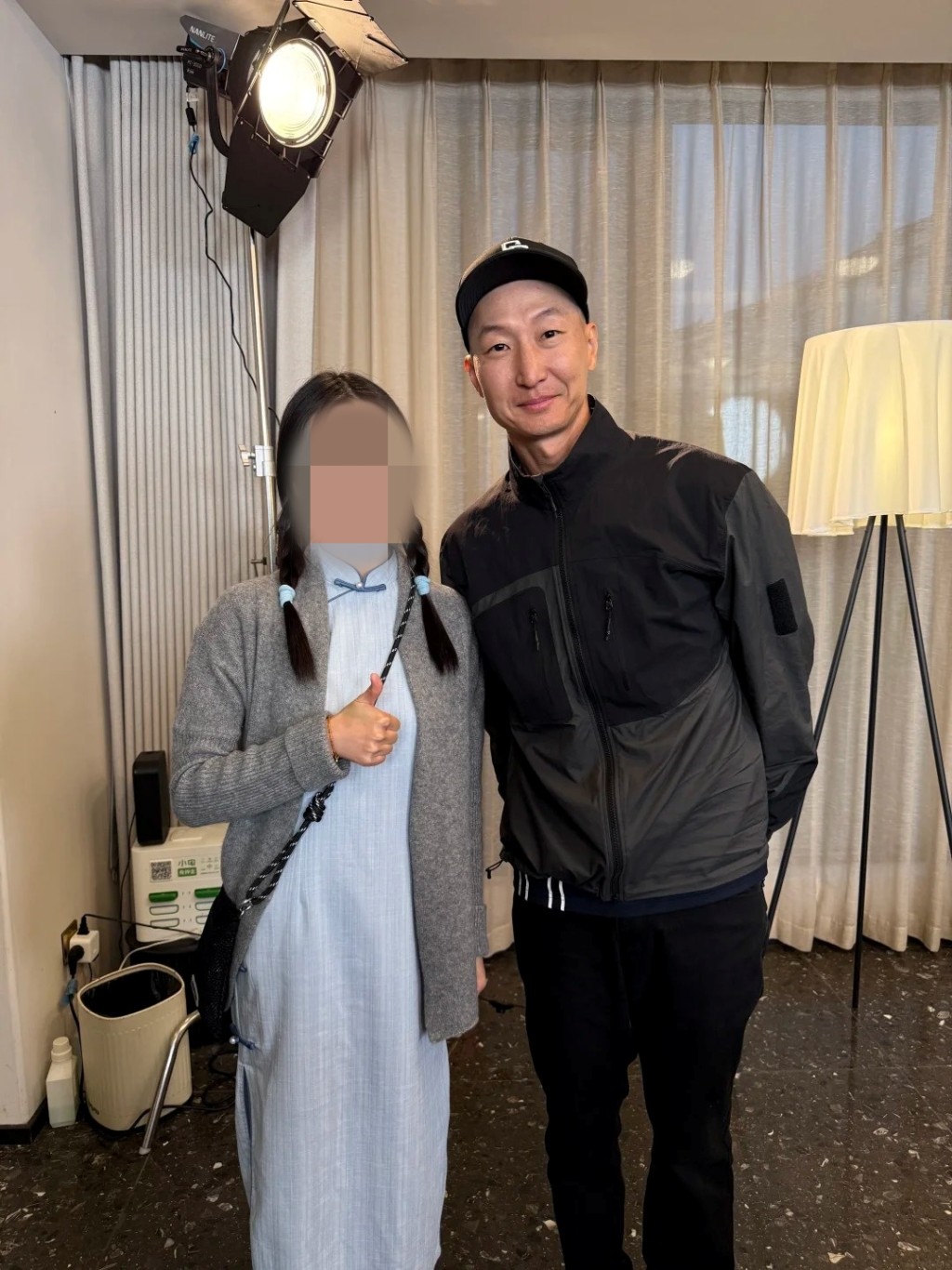 次子洪天祥身穿運動外套、戴棒球帽，對著鏡頭微笑，態度非常親民。
