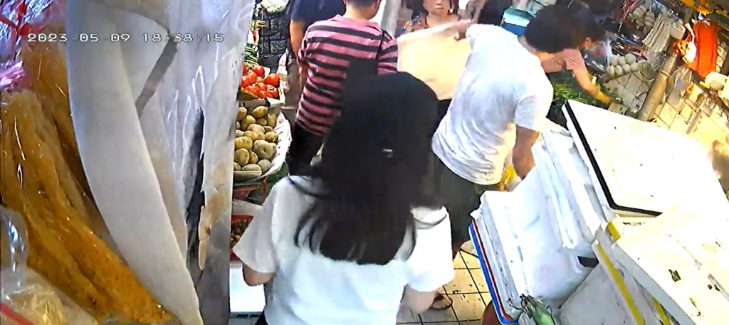 女菜販起身揮動發泡膠板還擊。