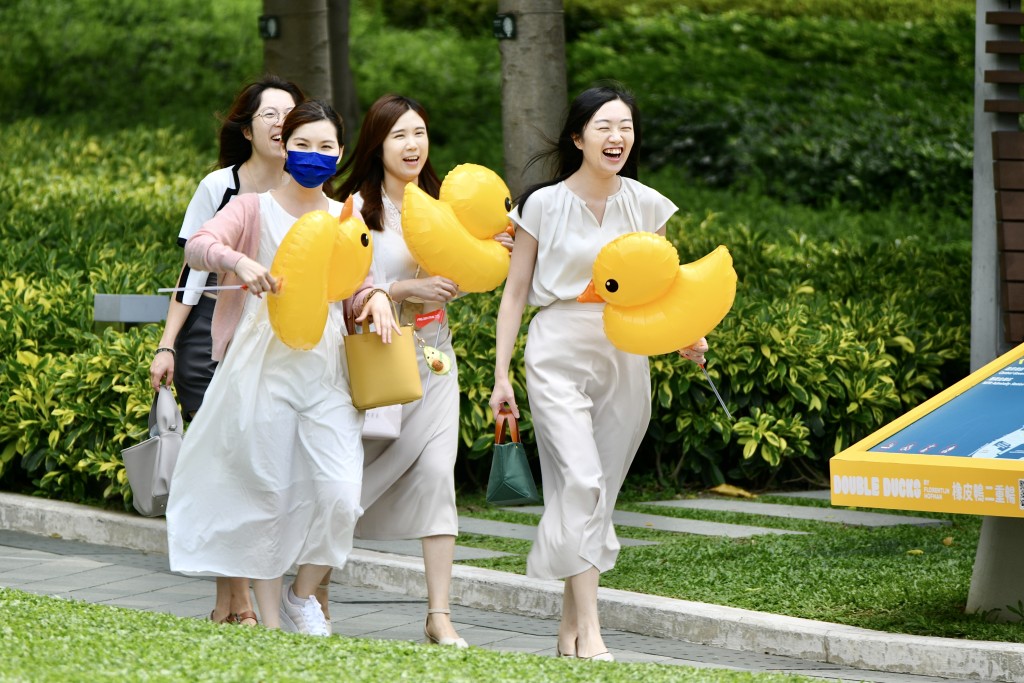 市民自备黄鸭气球与维港两只黄鸭打卡。卢江球摄