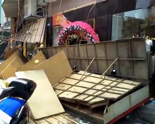 大型廣告牌倒塌後，佔據了整條行人路，多名途人受傷，包括老婦及孕婦。（網圖）