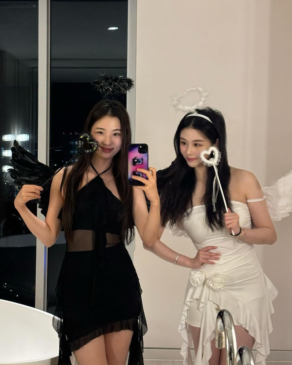 可以看到沈月身穿一条白色露肩连身裙配短裤，头戴天使光环，手中拿着魔法棒及孭上天使翅膀。