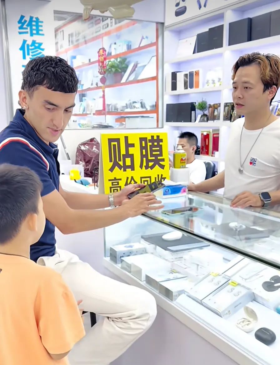 嘉瑋在華強北店舖充當翻譯,為外國遊客解決語言溝通問題。深視新聞 嘉瑋在華強北店舖充當翻譯,為外國遊客解決語言溝通問題。深視新聞