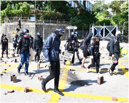 蒙面黑衣人行經解放軍軍營漆咸道南出入口。