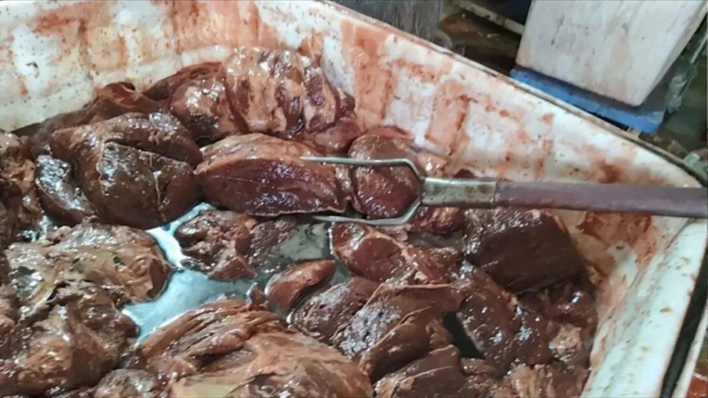长丰镇西杨屯村一家煮肉作坊内，工人正在腌制假驴肉。新京报