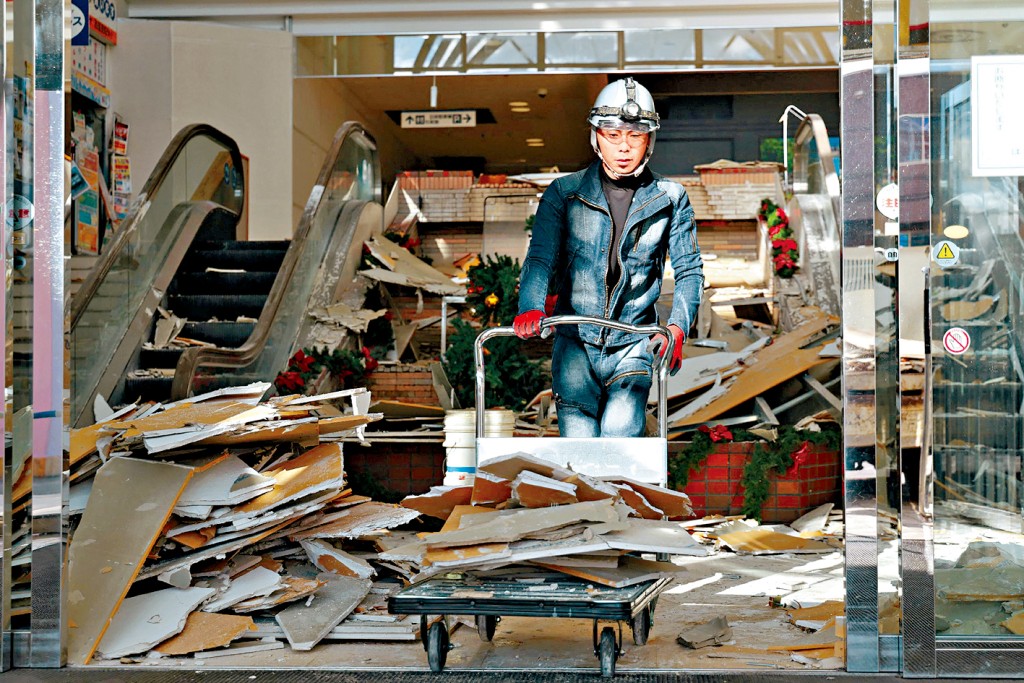 在青森縣八戶市有購物中心在地震中損毀，工作人員移走瓦礫。