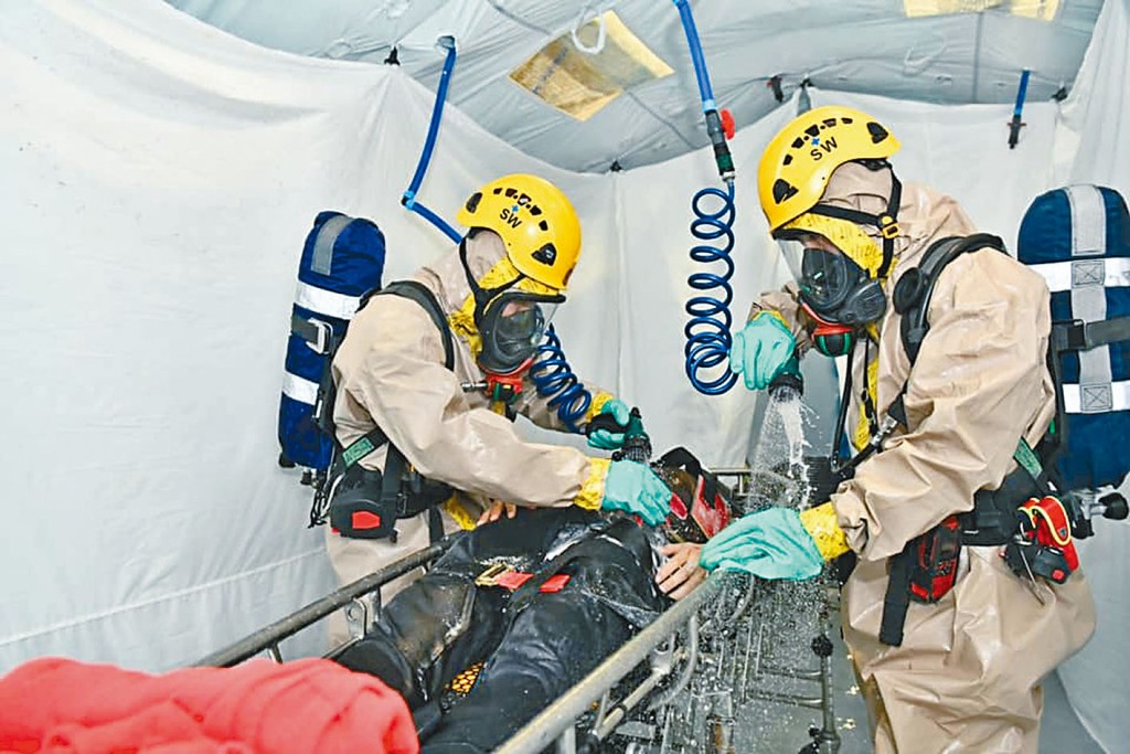 跨部门反恐及危害物质事故演习中，消防员为伤者清洗。